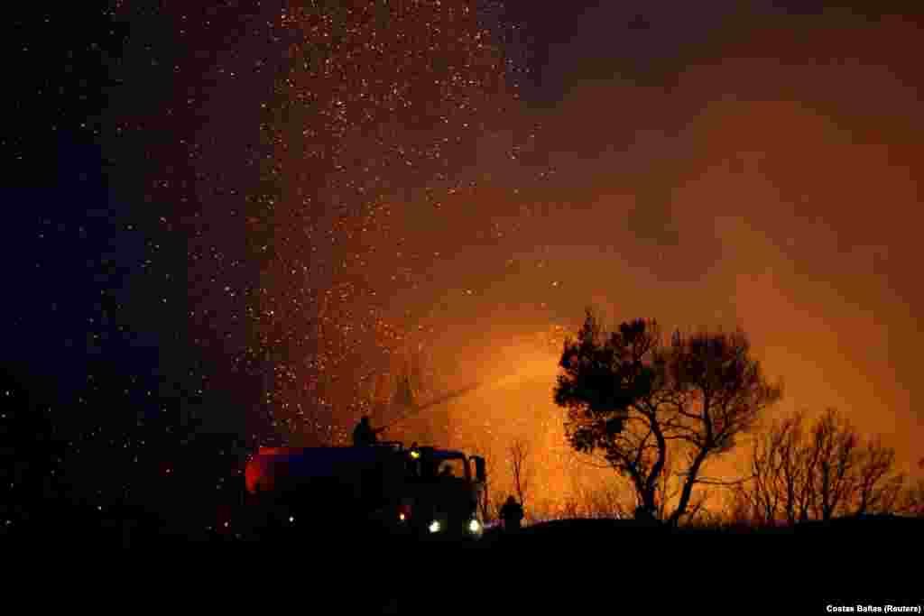Zjarrfikësit duke bërë përpjekje për shuarjen e një zjarri të egër në Varimpompi, në veri të Athinës, në Greqi. (3 gusht)