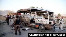 Afghan security officials inspect the scene of a bomb blast in Jalalabad on October 7.