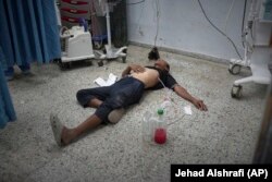 Një burrë i paidentifikuar, i pashoqëruar, duke qëndruar në dyshemenë e spitalit Shifa teksa po merrte trajtim pas një sulmi raketor.