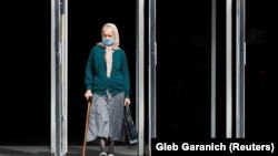 Жінка в захисній масці виходить із метро, Київ, липень 2020 року