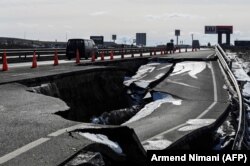 Veturat kalojnë pranë një rruge të prishur pas rreshjeve të shiut në Mazgit në janar të vitit 2021.