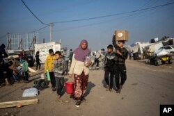 Awatif Abu Jarad duke bartur ujë në një kamp të improvizuar në zonën Muasi, në jug të Gazës. 1 janar 2024.