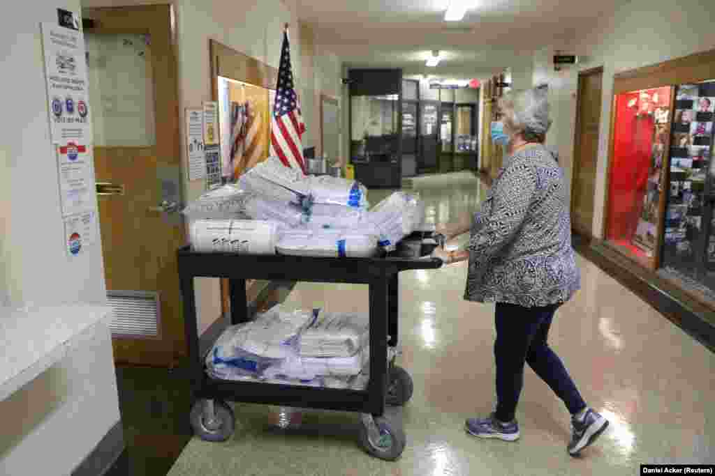 Изборниот службеник Шерон Крусон турка количка со гласачки ливчиња во Кеноша, Висконсин.