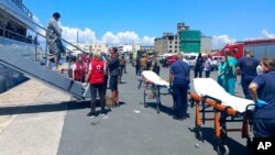 Оцелелите пристигат с яхта след спасителна операция на пристанището в град Каламата.