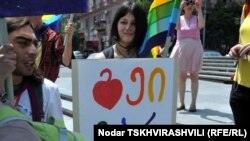 Мне запомнилась одна из них: привлекательная девушка с открытым чистым лицом идет под радужным флагом. В руках квадратная табличка с нарисованным сердцем и разноцветными грузинскими литерами. «Там написано "я – гей", - поясняет грузинский блогер и издеват