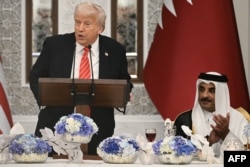 Эмир Катара шейх Тамим бин Хамад Аль Тани (справа) аплодирует речи президента США Дональда Трампа (слева) в начале государственного ужина во дворце Лусаил в Дохе. 14 мая 2025 года