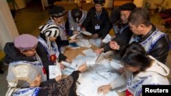Ош шаарындагы бир шайлоо комиссиясынын мүчөлөрү добуштарды эсептөөдө. 30-октябрь, 2011-жыл