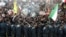 Security forces stand in front of a crowd during a ceremony marking the 31st anniversary of the 1979 Islamic Revolution in Tehran.