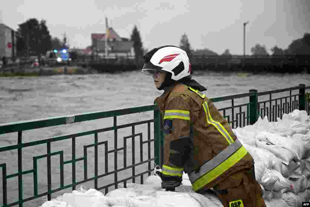 Vatrogasac pored vreća s pijeskom nagomilanim zbog poplava od nadošle vode rijeke Biala u Glucholazyju, na jugu Poljske, 14. septembra 2024.