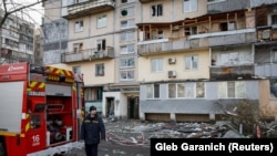 Спасатели на месте попадания российского дрона в Киеве, 23 марта 2025 года