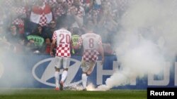 Hrvatski nogometaši uklanjaju baklje tokom utakmice sa Italijom 14. lipnja