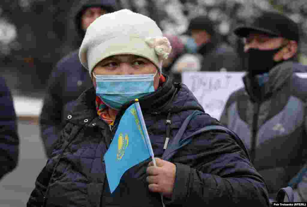 Женщина с флажком Казахстана на митинге в Алматы