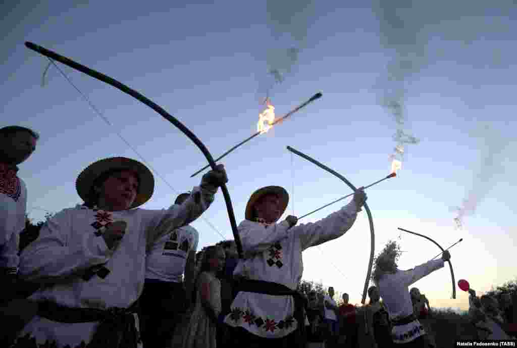 Чоловіки в етнічних білоруських&nbsp; костюмах випускають палаючі стріли під час урочистостей Івана-Купала