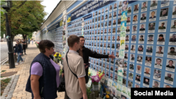 Андрій Коломієць із батьками біля стіни пам'яті в Києві