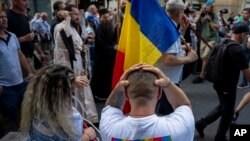 Un bărbat aflat la o terasă pe Calea Victoriei și-a pus mâinile pe cap în timp ce asista la o procesiune de „curățare” organizată de Biserica Ortodoxă Română pe traseul Bucharest Pride Parade, care avusese loc cu o zi înainte la București - România, 30 iulie 2023.