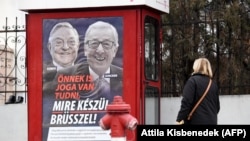 Afiș postat anul trecut, pe o cabină telefonică din Budapesta, cu portretul fostului șef al Comisiei Europene, Jean-Claude Juncker, și al filantropului american de origine maghiară George Soros.