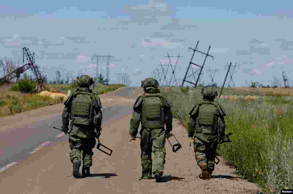 Украинанын оккупацияланган Марьинка шаарынын жанындагы автоунаа жолун минадан тазалап жаткан орусиялык сапёрлор. 