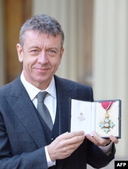 Питър Морган позира с медала си, след като е провъзгласен за Командир от Ордена на Британската империя, 19 февруари 2016 г.