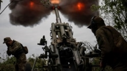 Un grup de soldați ucraineni manevrând un tun Howitzer în regiunea Harkov, Ucraina, 21 iulie 2022.
