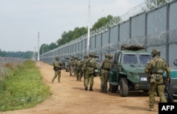 Польські прикордонники несуть варту біля огорожі на кордоні між Польщею та Білоруссю . Кринки, 25 серпня 2025 року