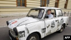 Unul din participanţii la picnicul de lângă oraşul Sopron, cu maşina decorată cu articole din presă despre evenimentul din 1989