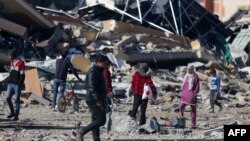 Disa palestinezë shihen në qendër të Rripit të Gazës të shkaktuar nga luftimet mes Izraelit dhe grupit palestinez, Hamas.