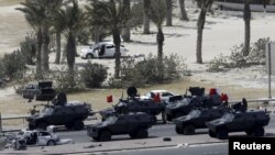 Перс булуңундагы кызматташуу кеңешине мүчө өлкөлөрдүн күчтөрү Манамадагы антиөкмөттүк демонстрациянын катышуучуларын Зумурут аянтынан көчүрүп чыгууда. Бахрейн. 16-май 2011-жыл. 