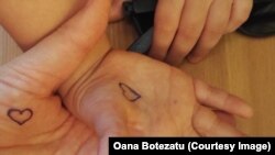 „Butonul spre inimă” tatuat în palma Oanei Botezatu e menit să o țină mereu aproape de copiii săi. Dacă sunt despărțiți fie și numai câteva ore, băiețașii apasă inima din propria palmă, iar ea comunică nevăzut cu inima mamei. Și toți se simt mai bine.