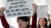Активисты стоят с плакатами против повышения пенсионного возраста женщин. Алматы, 26 апреля 2013 года.