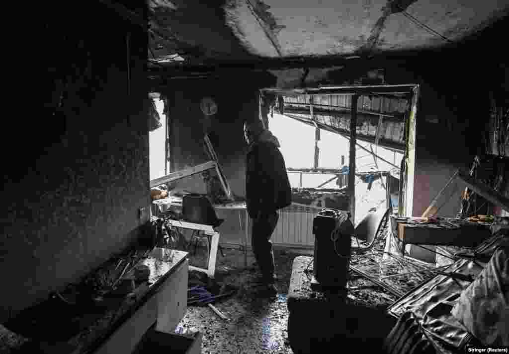 Чоловік оглядає свою квартиру, яка згоріла внаслідок російської атаки у Запоріжжі