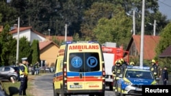 Një autoambulancë kalon pranë një polici dhe zjarrfikësve pasi një dron ose objekt i ngjashëm goditi një ndërtesë banimi në komunën Wyryki të Polonisë, më 10 shtator 2025.