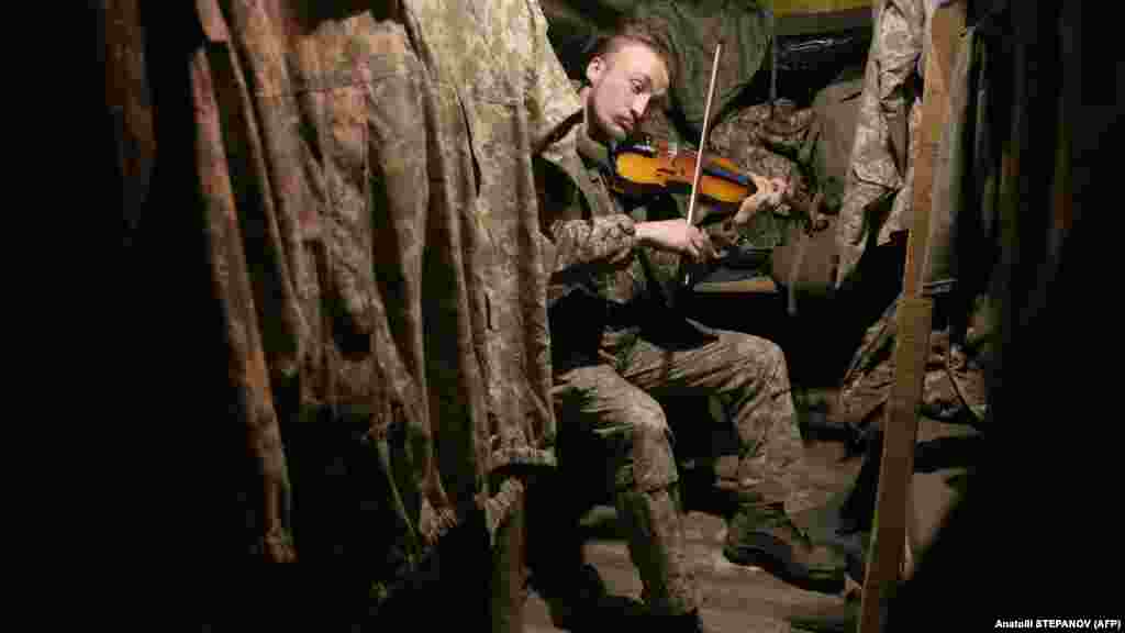 Egy ukrán katona hegedül a horlivkai frontvonalhoz közel 2020 decemberében. Sztyepanov &bdquo;egyfajta civil kötelességének&rdquo; érzi azt, hogy ilyen veszélyes körülmények között fotózzon. &bdquo;Talán túlzásnak hangzik, de így élem meg. Látszólag békés országban élünk, de igazából az a kérdés, hogy mikor fog előrébb mozdulni a frontvonal, ha fog, mert ennek az esélye is benne van a levegőben. Bármi bármikor megtörténhet.&rdquo;