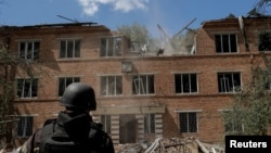 Un militar ucrainean inspectează urmările unui atac aerian rus asupra unui spital din Harkov, pe 25 iulie.