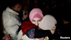 Një e burgosur palestineze përqafohet nga një grua tjetër pasi u lirua nga një burg izraelit si pjesë e një shkëmbimi pengjesh dhe të burgosurish dhe një marrëveshjeje armëpushimi në Gazë, më 20 janar 2025.