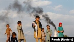 Afghan children stand by a brick-making factory on the outskirts of Jalalabad on November 13.