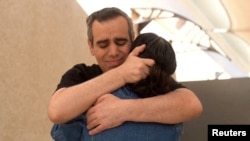 Omri duke e përqafuar gruan e tij.