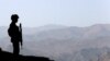 FILE: A Pakistan soldier stands guard along the border fence outside outpost on the border with Afghanistan in North Waziristan.