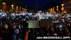 Protestatarii și-au aprins luminile telefonului mobil în timpul unei demonstrații în fața sediului Uniunii Creștin Democrate (CDU) din Berlin, pe 2 februarie 2025.