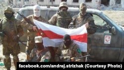 Українські солдати з білоруським національним прапором на тлі автомобіля, придбаного коштом волонтерів