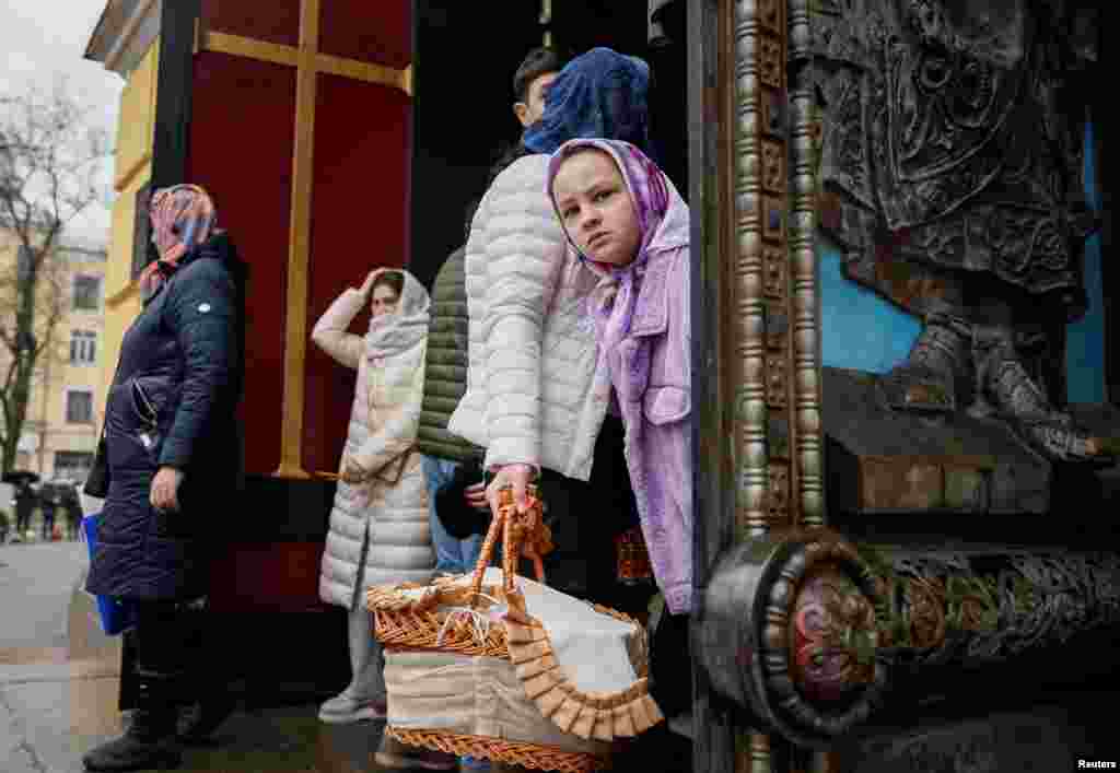 Një vajzë shikon nga dera e Katedrales Volodymyrsky, gjatë një shërbimi për Pashkët ortodokse në Kiev.