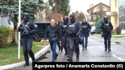 Policija privodi Horatiua Potru (u sredini) u Bukureštu 8. decembra 2024.