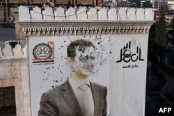 Portret Bašara el-Asada izrešetan mecima u gradu Hama, 6. decembar 2024.