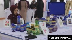 O femeie afgană vinde vase de sticlă la o expoziție de obiecte artizanale din provincia Herat în Afganistan. Multe au renunțat însă la astfel de activități exterioare gospodăriilor, după instalarea regimului taliban, în septembrie 2021.