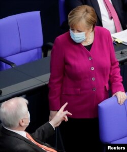 Nemački ministar unutrašnjih poslova Horst Seehofer razgovara s nemačkom kancelarkom Angelom Merkal u Bundestagu, u Berlinu, 25. marta 2021.