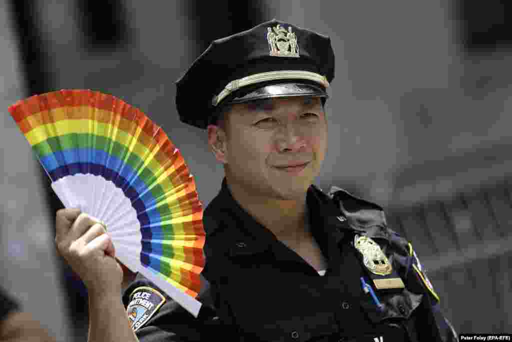 Un sergent de poliție din New York înfruntă un participant la cea de-a 52-a paradă anuală a Gay Pride Parade din New York. 27 iunie 2021.