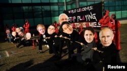 Manifstanți în Glasgow, purtând măștile liderilor planetei, joacă o scenă din foiletonul "Squid Game".