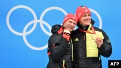 Франческо Фридрих (вляво) и Торстен Маргис позират със златните си медали от двуместния бобслей във вторник