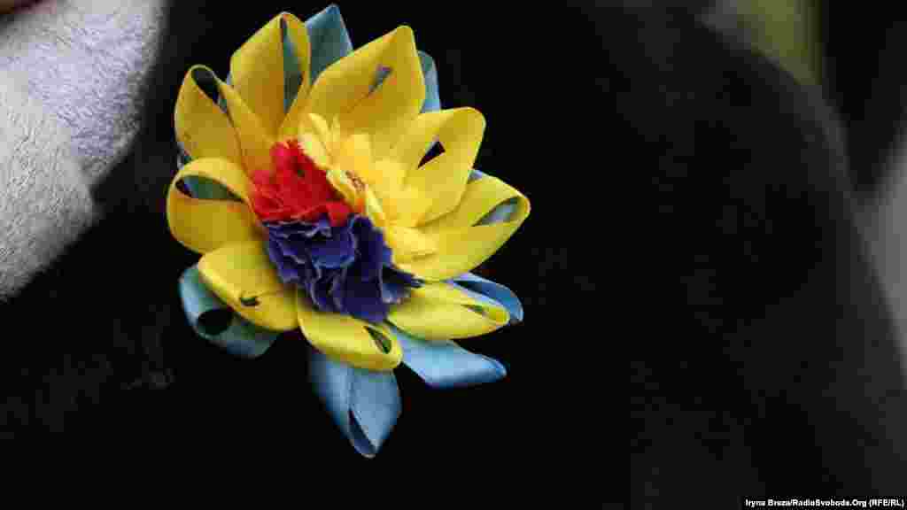 Саморобна бутоньєрка учасниці акції, зроблена у державних кольорах та червоно-чорній символіці&nbsp;