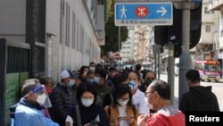 Ljudi sa zaštitnim maskama u redu za testiranje na COVID-19, Hong Kong, Kina, 14. februar 2022. 