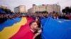 Учасники акції тримають великі прапори Румунії та Євроcоюзу під час мітингу напередодні переголосування президентських виборів у Бухаресті, Румунія, 9 травня 2025 року